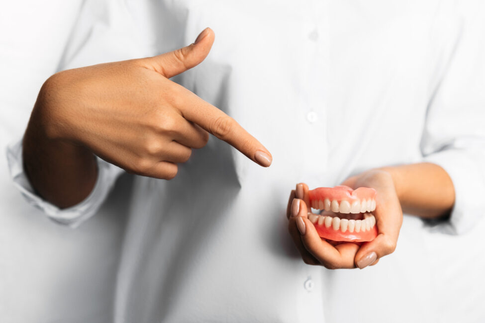 denture-in-the-hands-of-the-dentist-the-doctor-is-2022-02-02-20-32-08-utc dentures